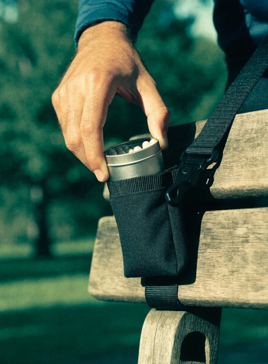 Une main refermant un petit sachet non imprimé posé sur une serviette de sport