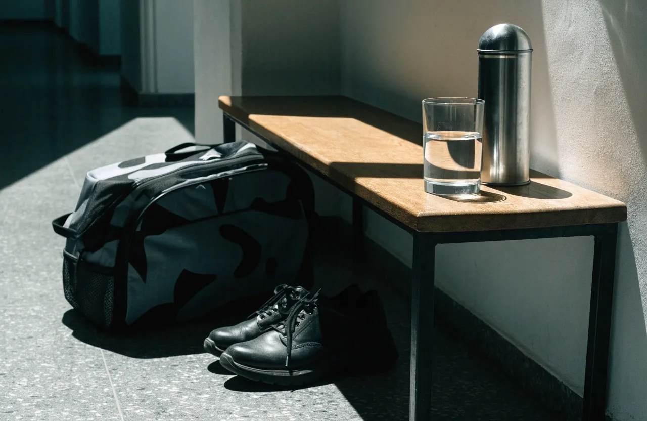 Shaker posé sur un rebord de fenêtre, condensation visible, serviette et chaussures au sol